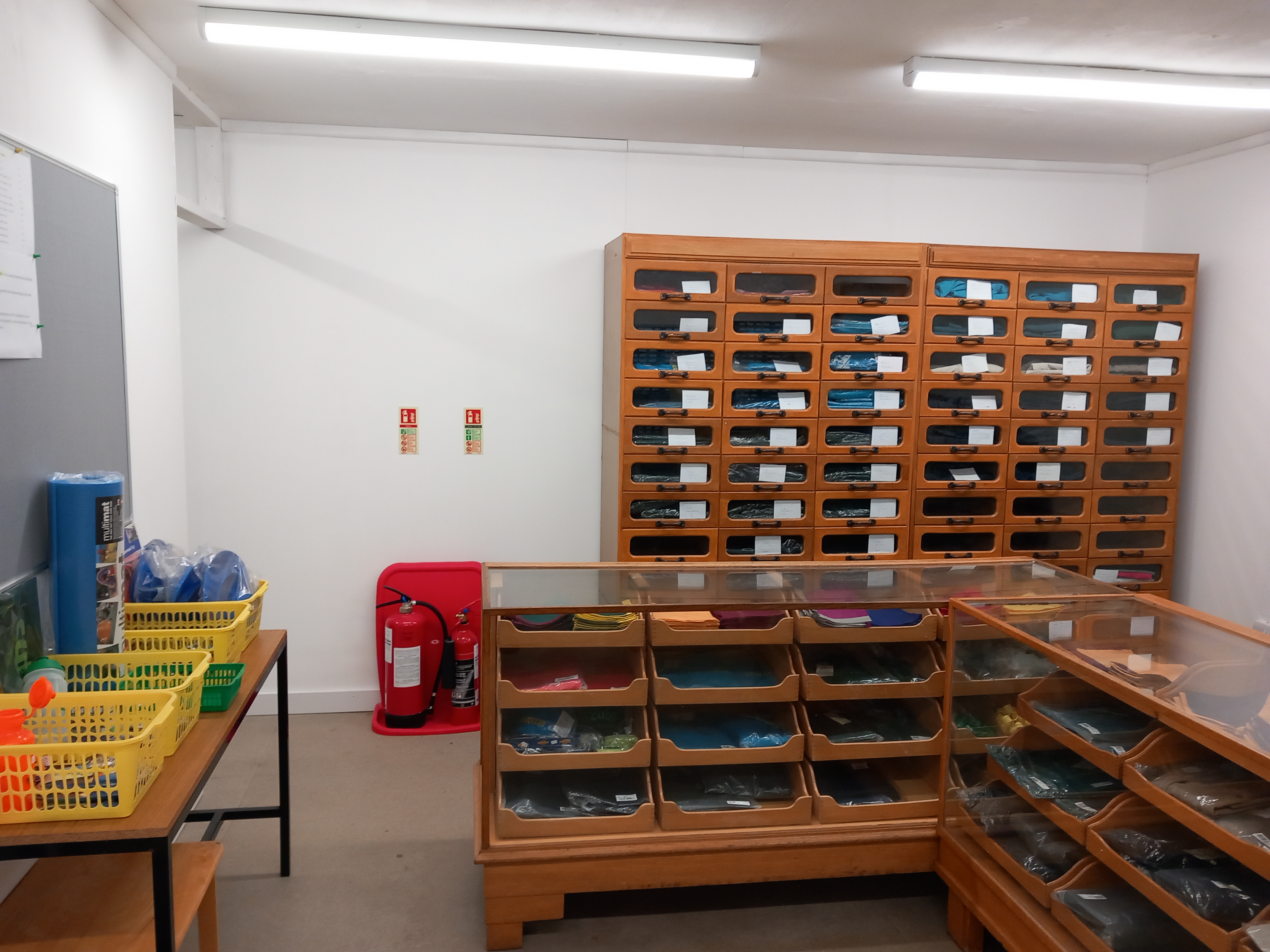 Wooden shop drawers and a rail of Scout uniform